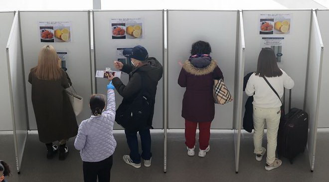 关西机场要求中国游客挂红绳吊牌以区分